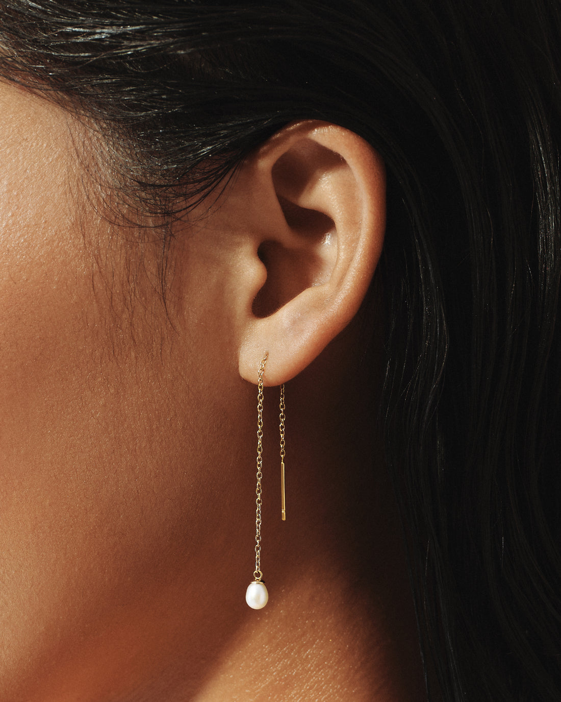 Model wearing Organic Pearl Threader Earrings in 14k gold, a single freshwater pearl falling below the ear