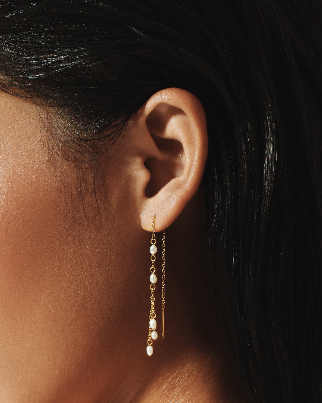 Model wearing Pearl Shower Threader Earrings in 14k gold, a cascade of freshwater pearls below the ear