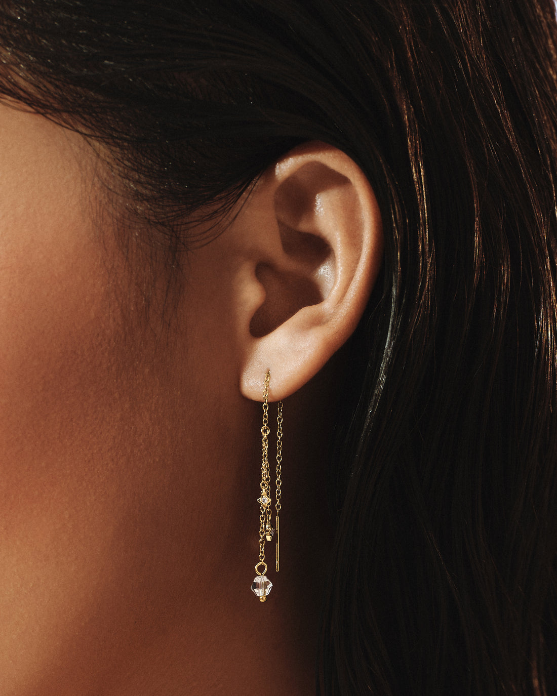 Model wearing Sparkle Threader Earrings in 14k gold, a line of crystals falling below the ear