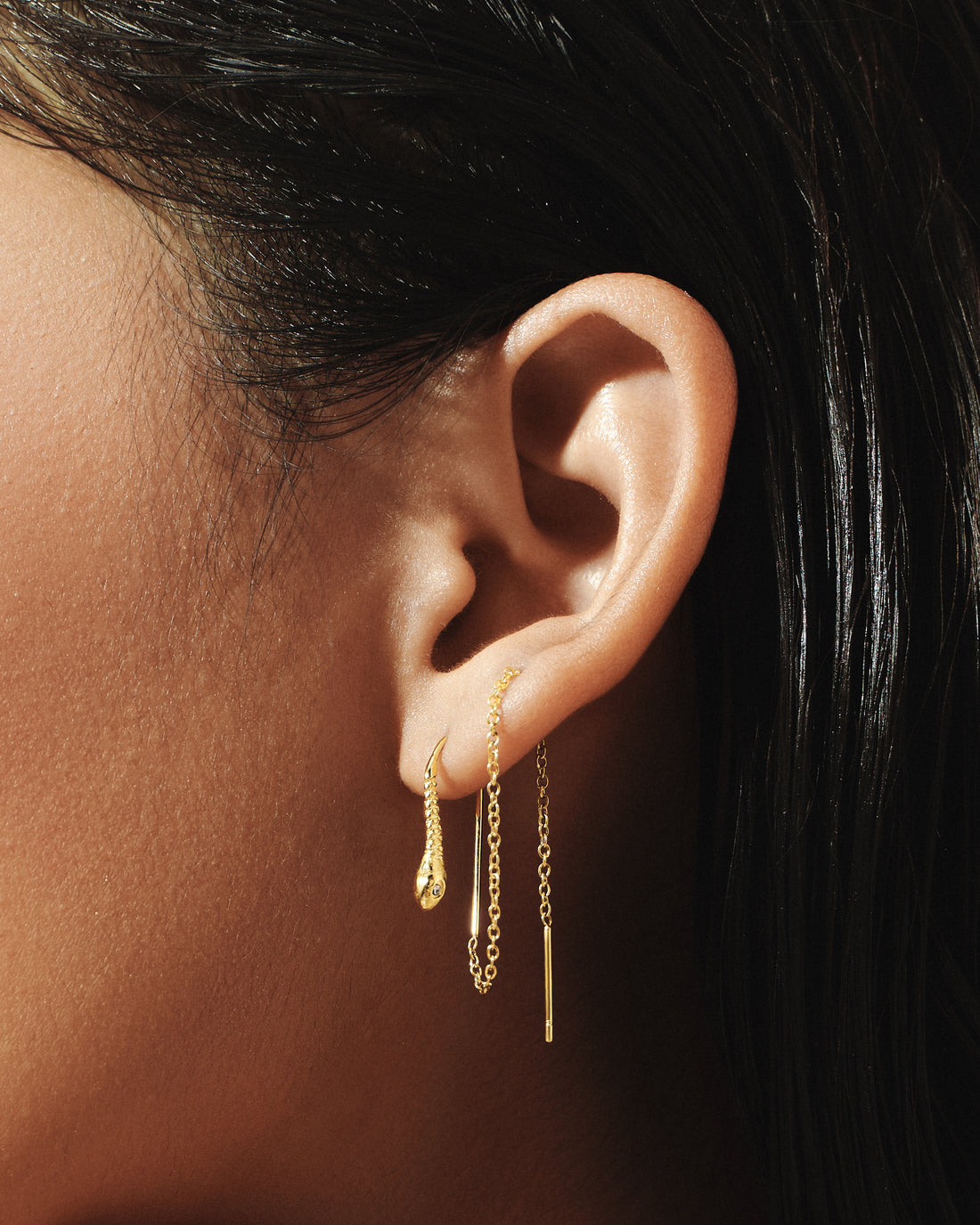 
Model wearing Snake Threader Earrings in 14k gold, a sleek chain gliding through the ear